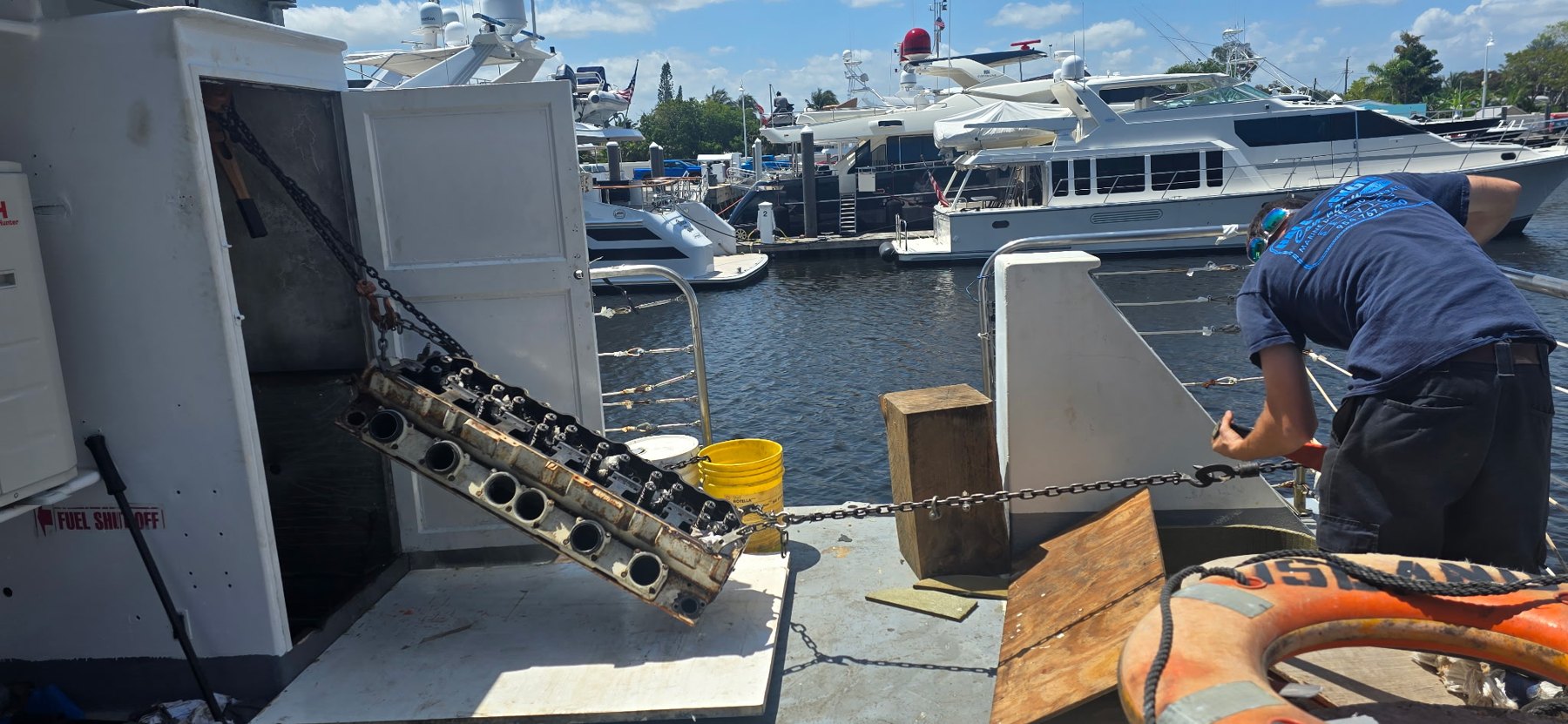 Marine diesel cylinder head rigging across yacht deck during service