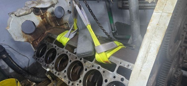 Large marine diesel engine block rigged inside yacht engine room