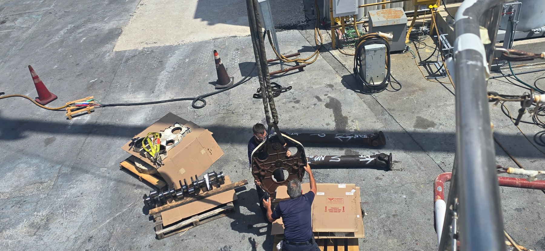 Marine diesel crankshaft and housing components staged in service yard