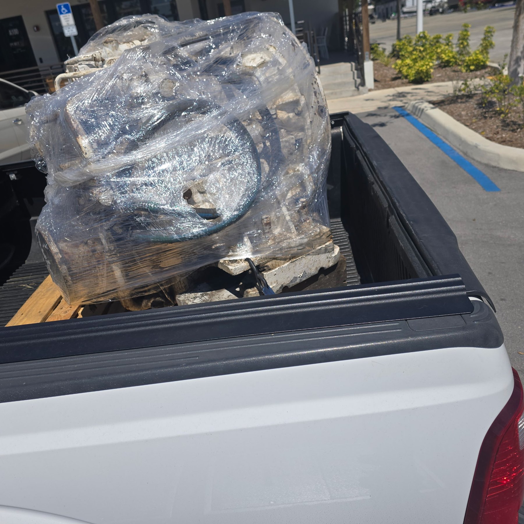 Marine diesel engine assembly wrapped and loaded in pickup truck for transport