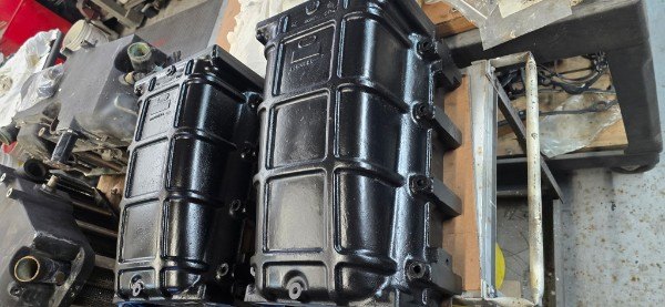 Refinished black marine diesel valve covers prepared for reinstallation