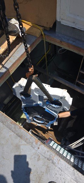 Marine engine component lowered through yacht access hatch for repair